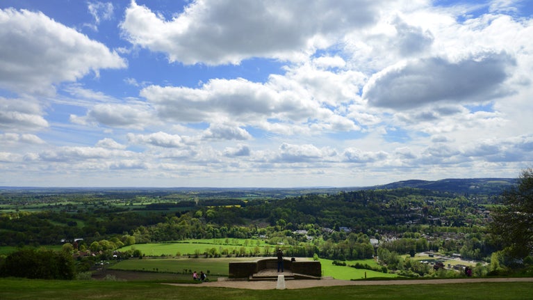 People standing at and around the view point at Box Hill, with a view over the town in the background
